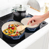 Cast iron braiser pan in use on stovetop with food cooking